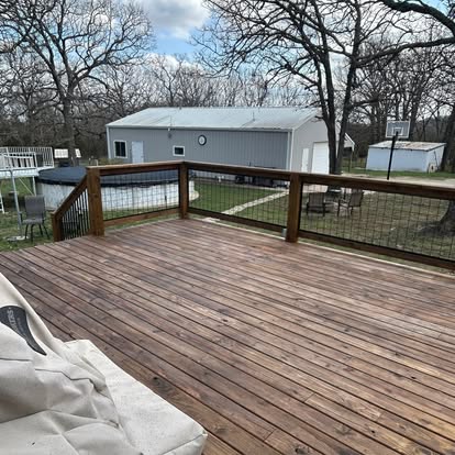 Large deck with freshly stained boards and wire railing