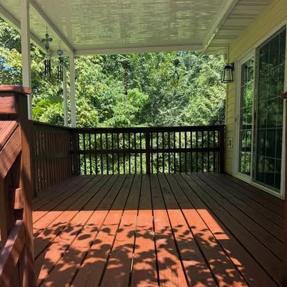 Covered deck with rich redwood-toned stain and dark railing